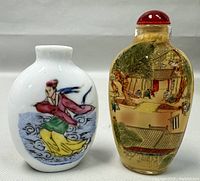 Pair of two Chinese reverse painted glass snuff bottles, one large 3 inch with red lid and courtyard scene, one smaller 2.5 inch with painted woman