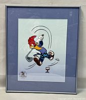 Framed animation cel artwork featuring Woody Woodpecker playing golf, showing full piece and frame.