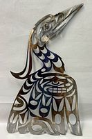 Front view of the metal heron showing detailed cutouts and clear finish with partial blue-black tinting on the body patterns.