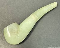 View of carved jade tobacco pipe showing polished rounded bowl and mouthpiece