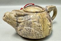 Front side view of dragon carved stone teapot showing detailed dragon head as spout and intricate scale carving.