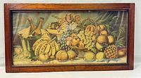 Front view of the framed fruit print showing a variety of fruits in baskets and bowls with a wooden frame.