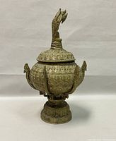 Front view of the bowl on pedestal, showing overall shape, embossed motifs, and serpent handles.