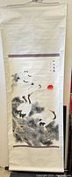 Full view of Chinese hand painted scroll on paper with cranes near pine trees and a red sun in the background, mounted on fabric backing with decorative purple frames.