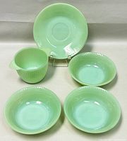 All five jadeite dishes displayed together showing dessert bowls, sugar bowl, and saucer
