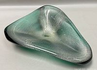 Top side view of a triangular vintage Murano blown glass dish showing green, black, and clear textured glass