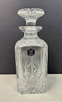 Full view of the Stuart cut crystal decanter with stopper in front of dark background showing the entire bottle and stopper.