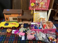 Dream Cottage dollhouse, original box, dolls, clothing, SuperVette car, and accessories laid out on plaid blanket