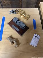 Photo of the two metal bulldog hood ornaments and the Mack Truck Forward Pumper model on a wood base.