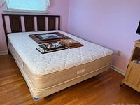 Full view of the bed with walnut headboard, mattress, and metal frame showing the overall lot contents