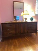 Full front view of walnut dresser with mirror and decorative lamps on top