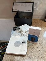 Top view of Ring Security Base Station with power adapter, keypad, paperwork, and boxes on a countertop.