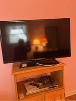 Samsung flat screen TV in room, showing front view and TV stand below.