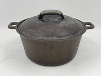 Full view of cast iron pot with handles and lid from the front angle.