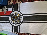 Full view of the Imperial German flag showing the Iron Cross in the upper left, central eagle emblem, and cross design.