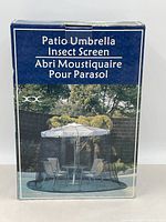 Photo of the packaging for patio umbrella insect screen by Axxonn showing product name and image of the screen installed over patio table and chairs.