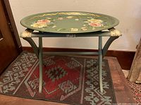 Folding stand supporting the detachable beverage tray placed on top, showing the full stand structure including cross supports and tubular legs.