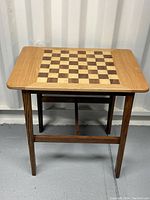 Full view of the wood chess table showing inlaid chessboard on top and table legs.