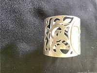 Close-up front view of the sterling silver cuff showing intricate scrollwork filigree pattern.