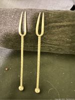 Photo of two antique silver forks showing twisted handles and two prongs
