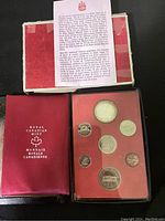 Photo of the complete coin set displayed in red Royal Canadian Mint case with original box behind
