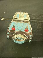 Front view of handmade hinged enamel cuff bracelet showing blue and red enamel with metal framework and pin clasp.