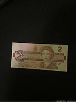 Front side of one $2 Canadian paper banknote showing Queen Elizabeth II and denomination.