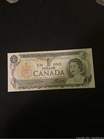 Photo of a 1967 Canadian one dollar bill featuring Queen Elizabeth II in mint condition.