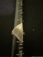 Close-up photo of one silver ring on a measuring tool confirming size 7 with a triangular design.