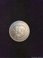 Obverse side of coin showing Princess Diana and Prince Charles side profiles with the 1981 date.