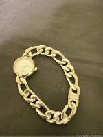 Photo showing the women's Cardinal wristwatch with a silver chain link bracelet and round watch face on a dark background.