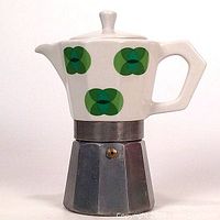 Full side view front profile of vintage stove top espresso maker with porcelain upper chamber decorated with green geometric floral patterns and octagonal aluminum base.