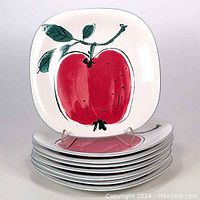 Stack of eight 1990s Studio Nova Just Fruits dinner plates with stylized red apple design and green leaves on square white plates.