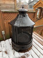 Front view of the metal outdoor fireplace on snowy deck