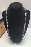 Image showing the hematite and pearl necklace displayed on black stand to illustrate design and length.