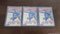 Six identical Auston Matthews rookie hockey cards from 2016-17 Topps Heritage series, red border, in protective plastic holders, arranged on a wooden surface.