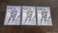 Three Doug Weight rookie hockey cards, identical, each in clear protective holders, showing player on ice in hockey gear.