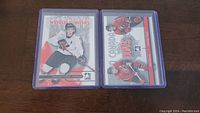 Two Jonathan Toews rookie hockey cards, one showing Jonathan in a white Team Canada World Juniors uniform and the other showing two players in red uniforms, both cards in protective sleeves.