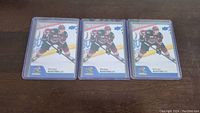 Three Michael Bunting rookie hockey cards placed side-by-side on a dark surface, each in clear protective sleeves.