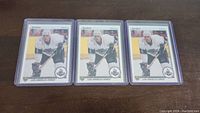 Three Rob Blake rookie hockey cards in protective sleeves placed side by side on a table.