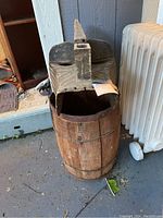 Front angled view showing full wine barrel and attached carved mask with open mouth.