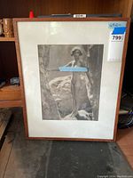 Front view of framed and matted black and white photographic print showing nude woman and wooden frame.