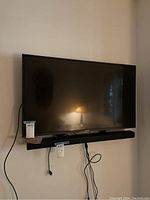 Sony 44 inch TV mounted on a wall with visible cables and wall mount bracket. Sound bar beneath TV not included.