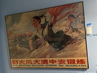 Front view of the framed Chinese propaganda poster mounted on a wall.