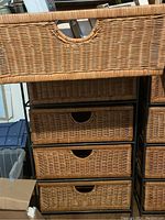 Front view of wicker drawers showing the weaving pattern and cutout handles.