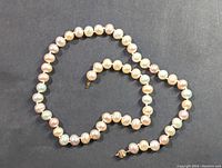 Full view of the pearl strand necklace showing pastel pearls.