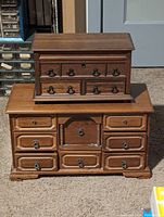 Two wooden jewelry storage cases stacked, showing overall condition and design.