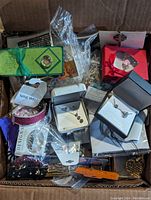 Box with assorted jewelry packages, showing various boxed and packaged jewelry items including bracelets, earrings, and necklace sets.