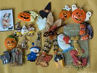 Full collection of Halloween-themed brooches spread out on a yellow surface.