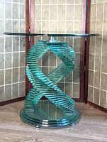 Full view of clear glass side table showing spiral base and round top